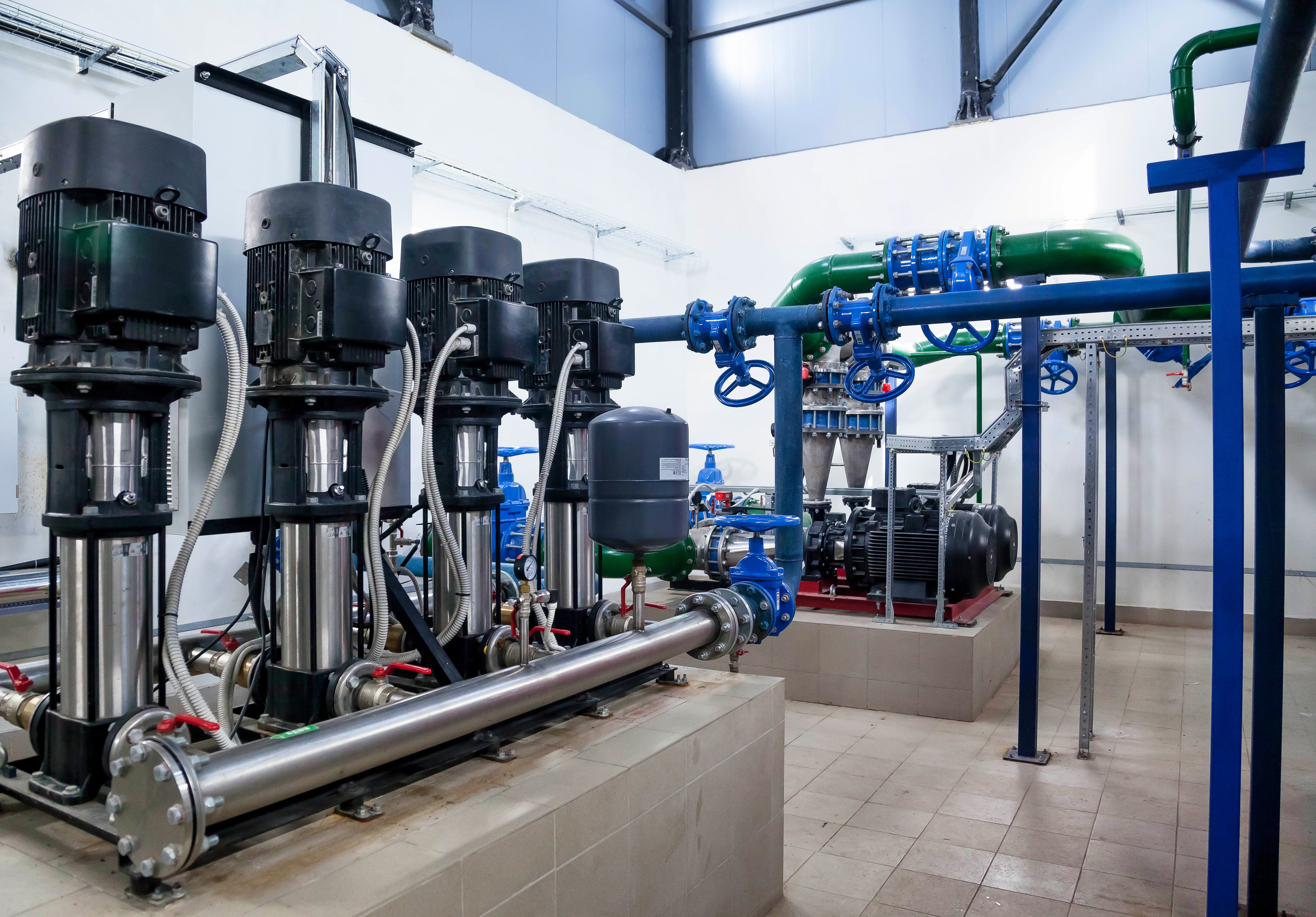 Multi-pump skid with piping and valves in a plant room