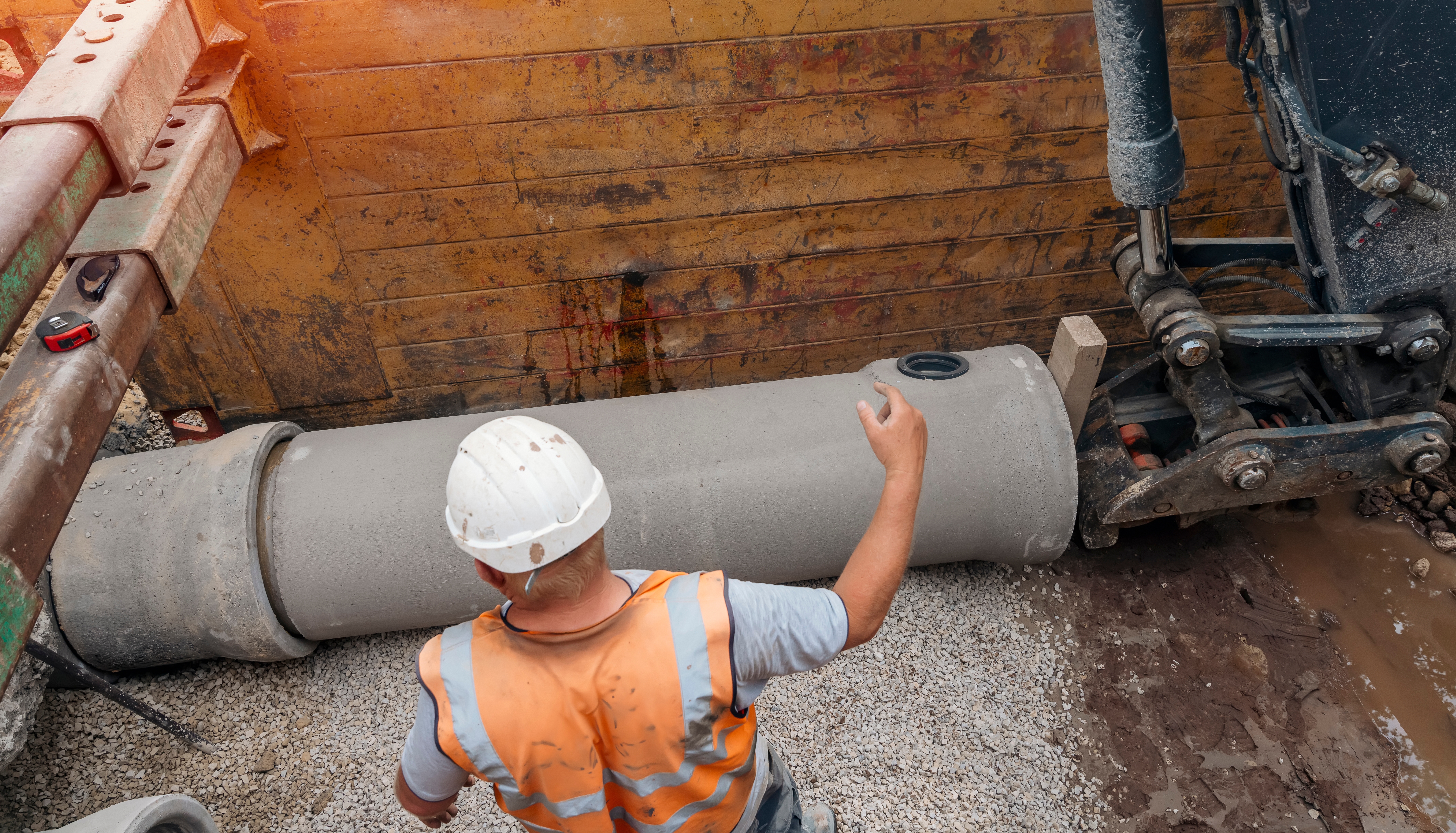 Field worker handling a pipe section during installation